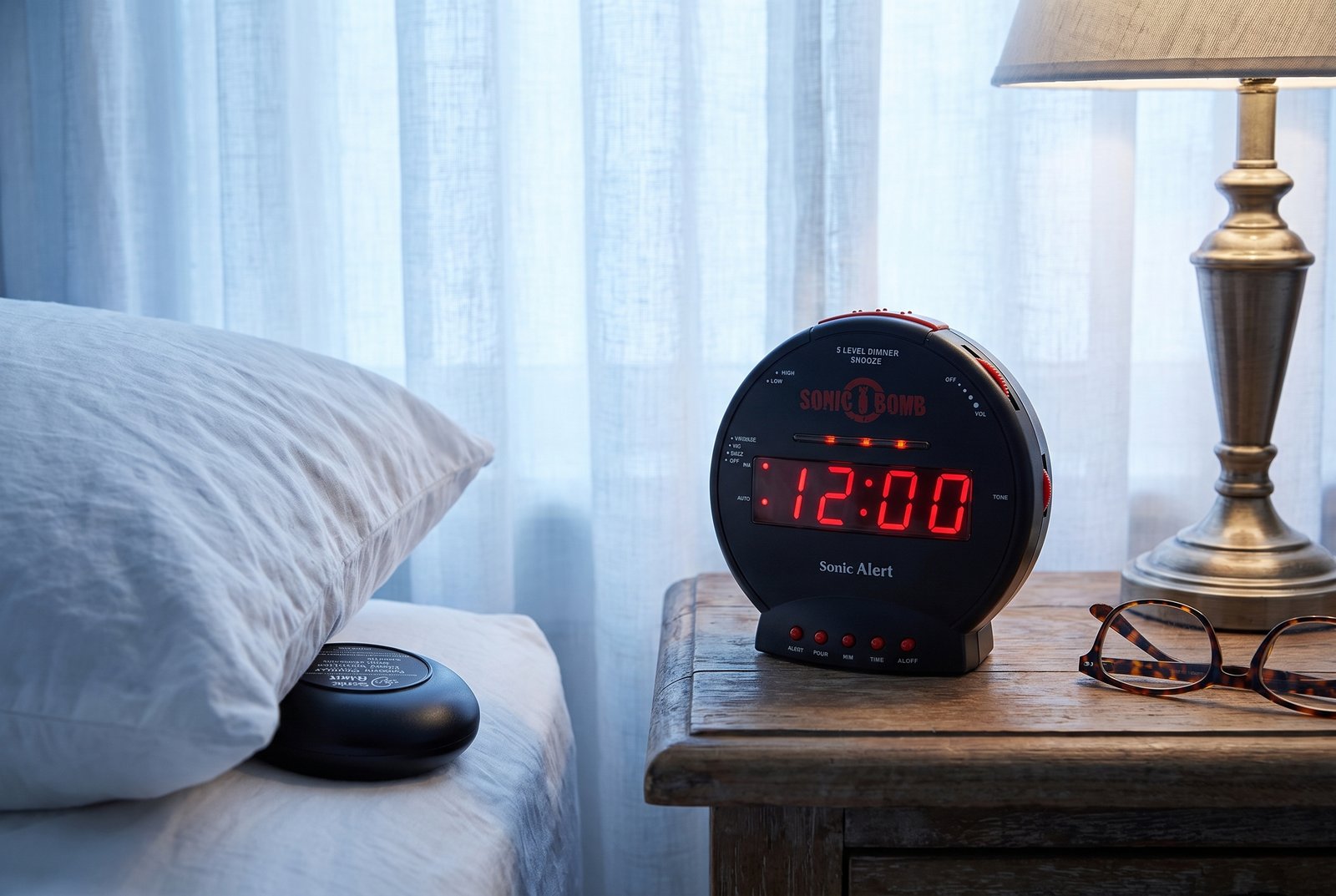 Sonic Bomb extra-loud alarm clock with bed shaker on a nightstand at dawn