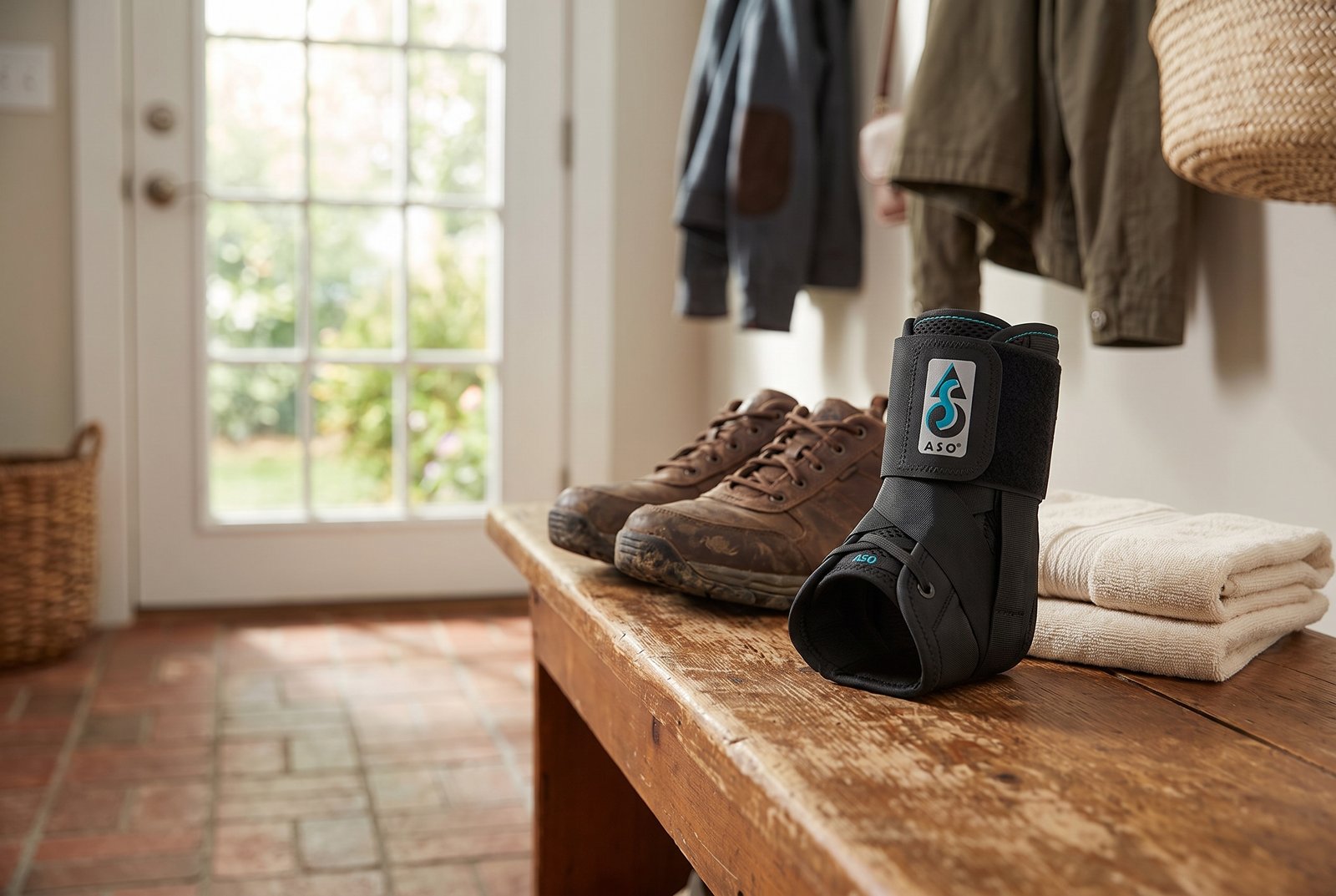 Med Spec ASO lace-up ankle brace on a mudroom bench beside walking shoes